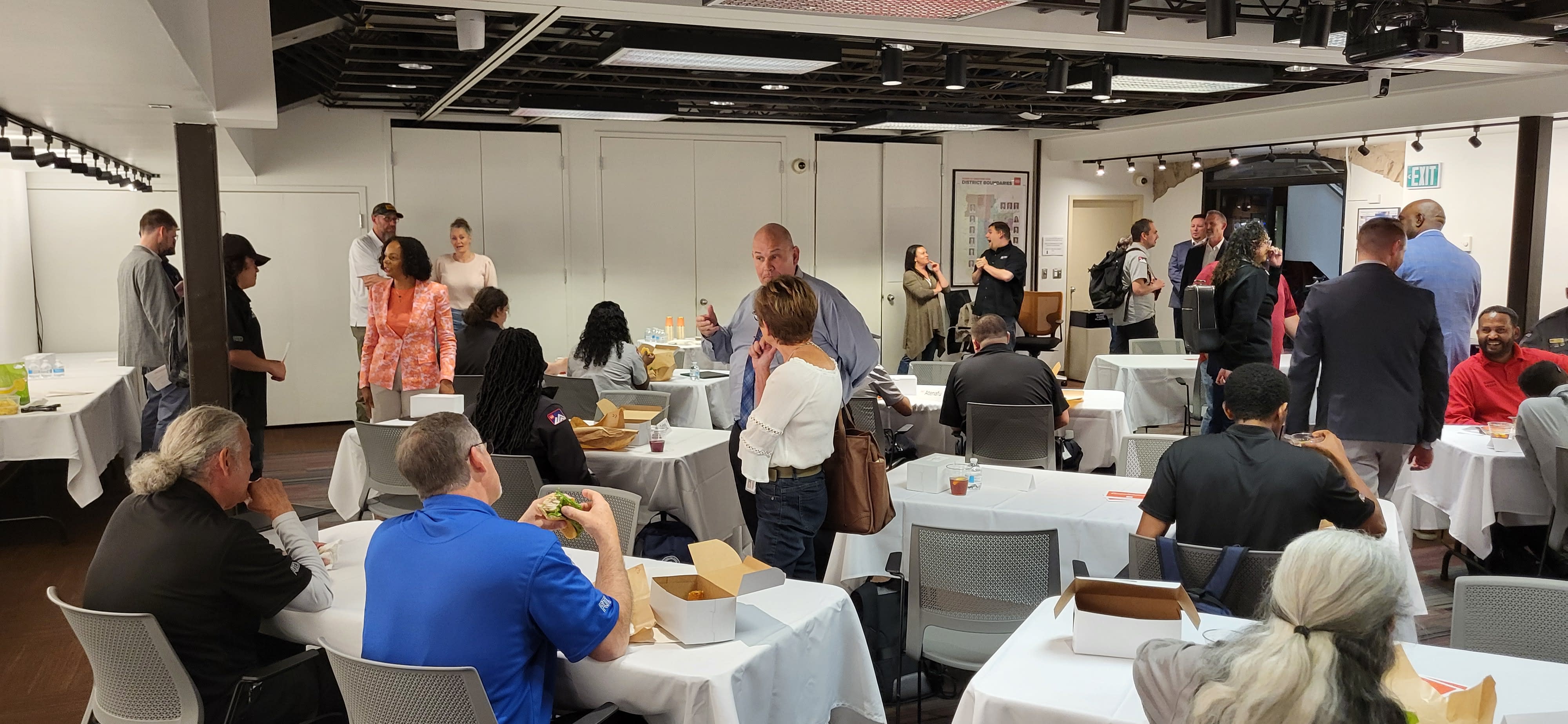 Room with tables and recent graduates having lunch at a reception.