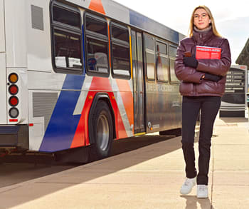 Girl walking next to a bus that is stopped