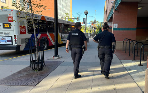 Des agents de la police de la RTD marchant à côté d'un bus