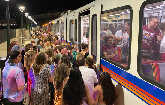 Crowd of customers boarding a light rail train after a concert