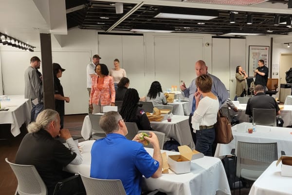 Room with tables and recent graduates having lunch at a reception. thumbnail
