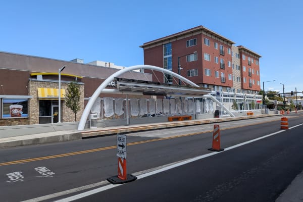 A photo of a newly-installed arch over an E. Colfax BRT station thumbnail