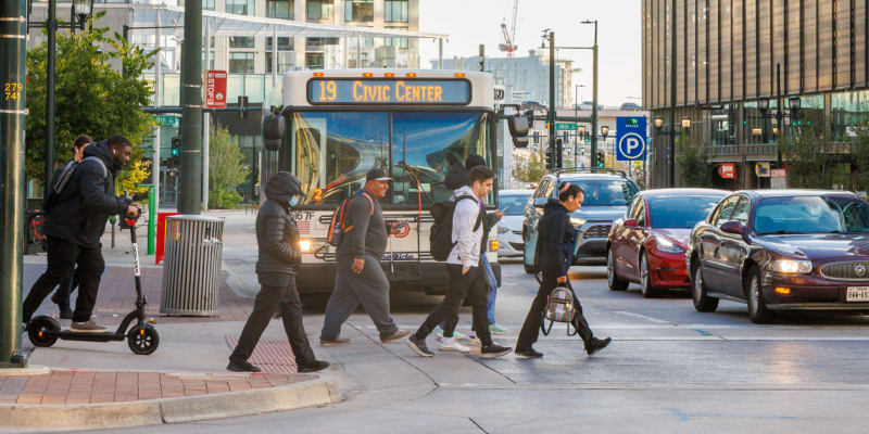 People walking on busy street with RTD bus in the background