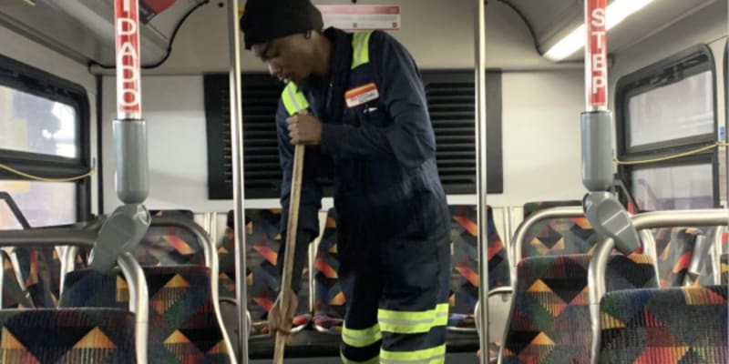 Staff person sweeping bus