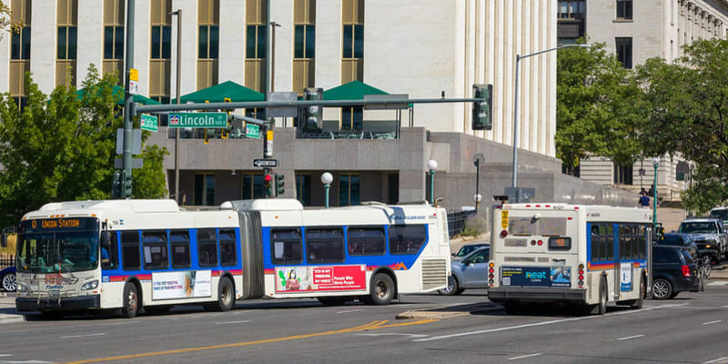 Two RTD buses at Colfax and Broadway