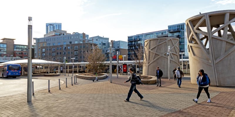A photo of people walking near planters on the light rail platform at Union Station