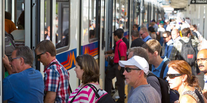a photo of people boarding a light rail train.