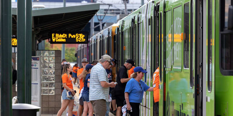 a photo of people boarding a light rail train.