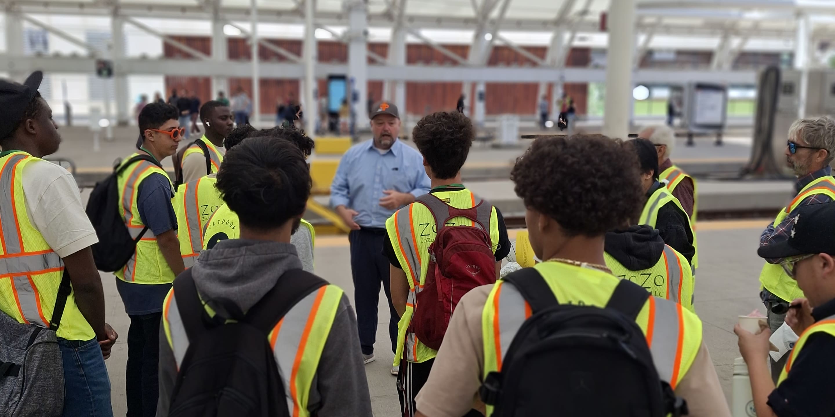A photo of students standing with DTP GM Nate Morgan on the commuter rail platform at Union Station