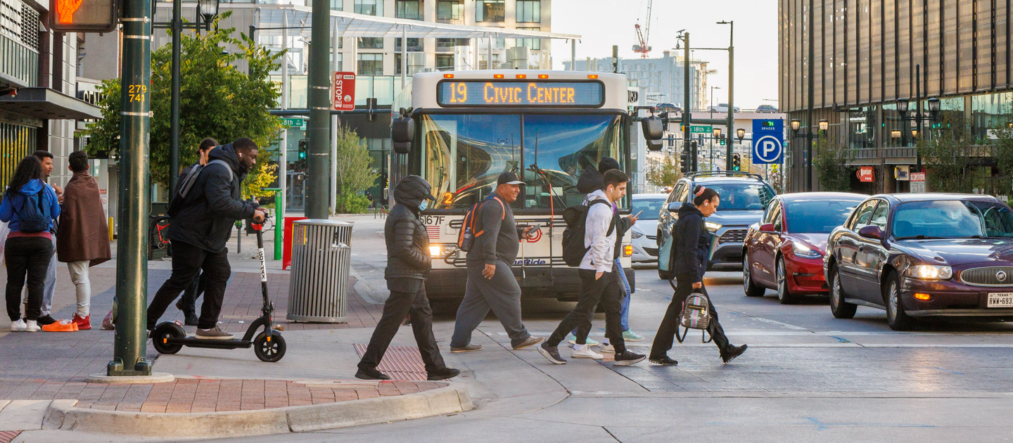 People walking on busy street with RTD bus in the background