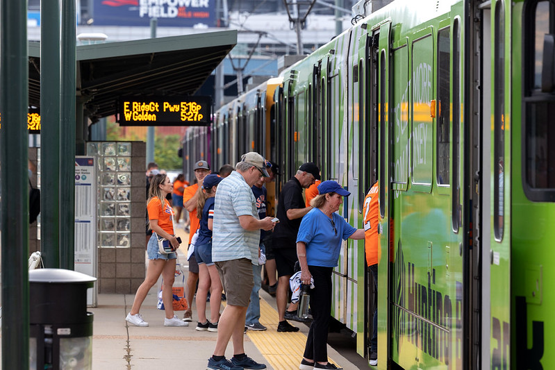 a photo of people boarding a light rail train.